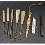 Collection of sewing implements including a silver folding button hook with mother of pearl handle.