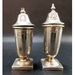 Silver salt and pepper shaker of plain pedestal form upon square foot, maker EV, Sheffield 1958,