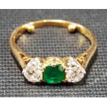 18ct gold three stone diamond and emerald ring, the central emerald of 0.25ct spread approx