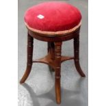 Circular adjustable piano stool on four turned legs.