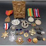 Collection of military medals and badges including a WWII Defence Medal, a German Third Reich badge,