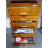 A modern brassbound teak seven drawer chest containing a quantity of vintage Meccano parts and