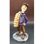 A Will Young Devon Pottery figure of a French man carrying a string of onions, signed to the base,