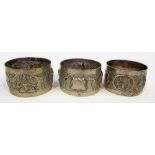 Indian white metal napkin ring decorated in relief with deities; together with a pair of Indian