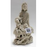 A Chinese blanc de chine porcelain model of Guanyin seated upon a rocky base, a scroll in her