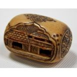 Meiji period ivory netsuke, of oblong form, carved and pierced with opposing building, the ends with