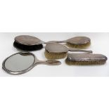 Five silver engine turned dressing table items including a hand mirror.