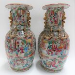 A large pair of Cantonese famille rose vases, the flared necks applied with Fo dog lug handles,