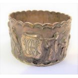 Chinese export white metal napkin ring cast and chased with figures within a garden, weight 29.8g