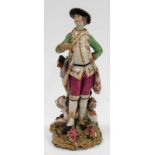 A Chelsea 18th Century porcelain figure of a standing huntsman, a reclining hound at his feet and on