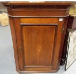 George III oak wall hanging corner cupboard, the panelled door with shell marquetry oval paterae