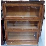 'The Lebus Bookcase' oak three section bookcase with shaped gallery upon plinth base, width 34.75in