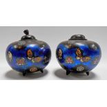 Pair of Japanese cloisonné ovoid lidded vases, the sides decorated with butterflies on a blue