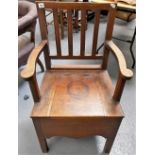 George III oak elbow chair commode with square comb back.