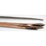 A tribal long bow with four long reed arrows with barbed ends, length of bow 83in