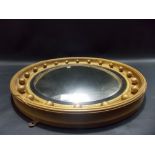 Regency-style circular gilt framed convex wall mirror with applied balls, diameter 24.5in overall.