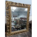 19th Century rectangular bevel edged gilt wood and gesso mirror, the frame with pierced and carved