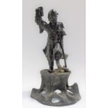 Chinese bronze figure cast as a sage with walking stick, one arm aloft and on a naturalistic base,