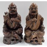Pair of oriental opposing root carved seated jovial Buddhas, both holding beads and a sceptre,