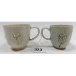 Two 18th Century bow 'blanc de chine' teacups, both with three raised moulded blossom sprigs