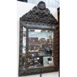 Dutch copper embossed framed cushion mirror, the surmount with shell and foliate scroll