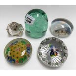 Five 19th Century glass paperweights including a green glass Nailsea dump, one other depicting the