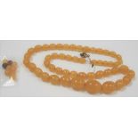 Yellow amber oval graduated bead necklace, weight 41.4g together with nine blue small beads