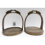 Two similar Chinese bronze stirrups, with double dragon tops, height 6in