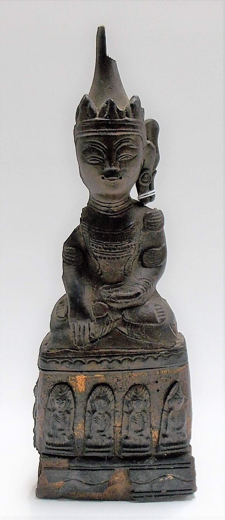 Oriental carved wood crude figure of Buddha seated, the base with a phrase of four arched figures,