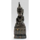 Oriental carved wood crude figure of Buddha seated, the base with a phrase of four arched figures,