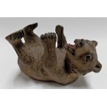 Black Forest carved reclining bear with glass inset eyes, the base inscribed in ink 'GENEVA T A REED