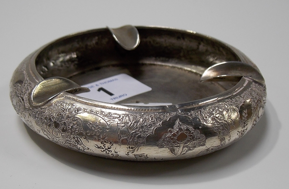 Eastern white metal circular ashtray with foliate engraved decoration, marks to the base, weight