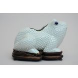 A 'frog' in Chinese porcelain on a wooden base (20x27x14cm)