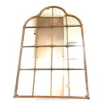 A gilt metal architectural design arched wall mirror