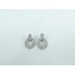 A pair of silver and CZ earrings.