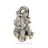 A cast sterling silver figure of a seated elephant with sapphire set eyes