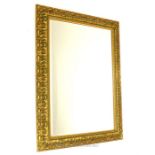 A rectangular ornamental wall mirror with moulded, gilt frame