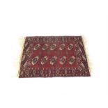 A Persian rug with a deep maroon ground with black and white motifs