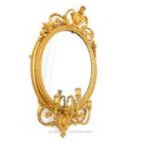 A 19TH CENTURY GILT FRAMED GIRONDEL MIRROR; crested with a floral cartouche above three candle