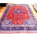 A large Isfahan carpet with a floral medallion on a red field