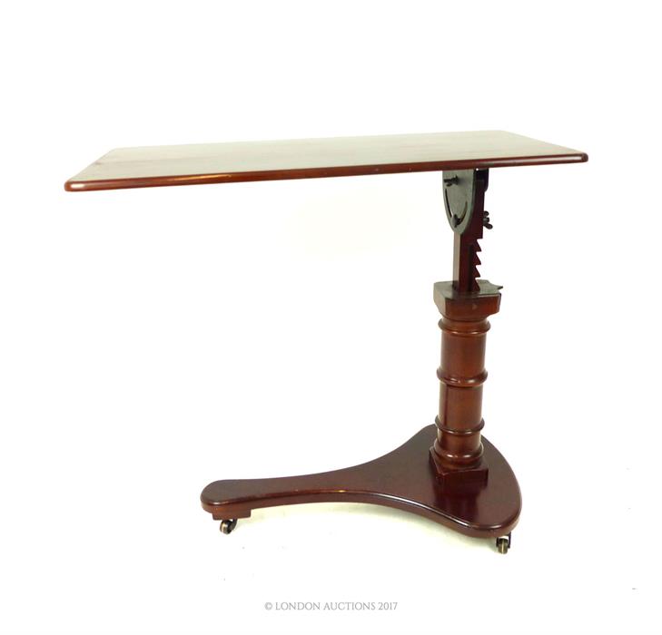 A mahogany over bed table; 81 cm wide