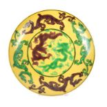 A Chinese yellow dish adorned with hand-painted green and brown dragons