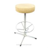 A stylish, vintage chrome stool with ivory faux leather seat