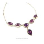 A silver and six faceted amethyst stone necklace