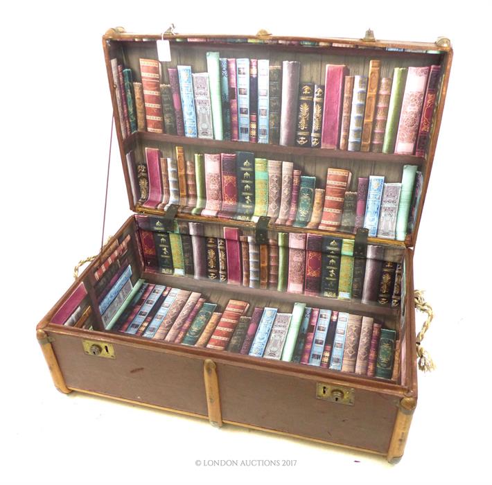 A brown vintage wooden bound trunk with a printed lining of book spines