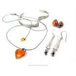 A Baltic amber heart form pendant together with other jewellery