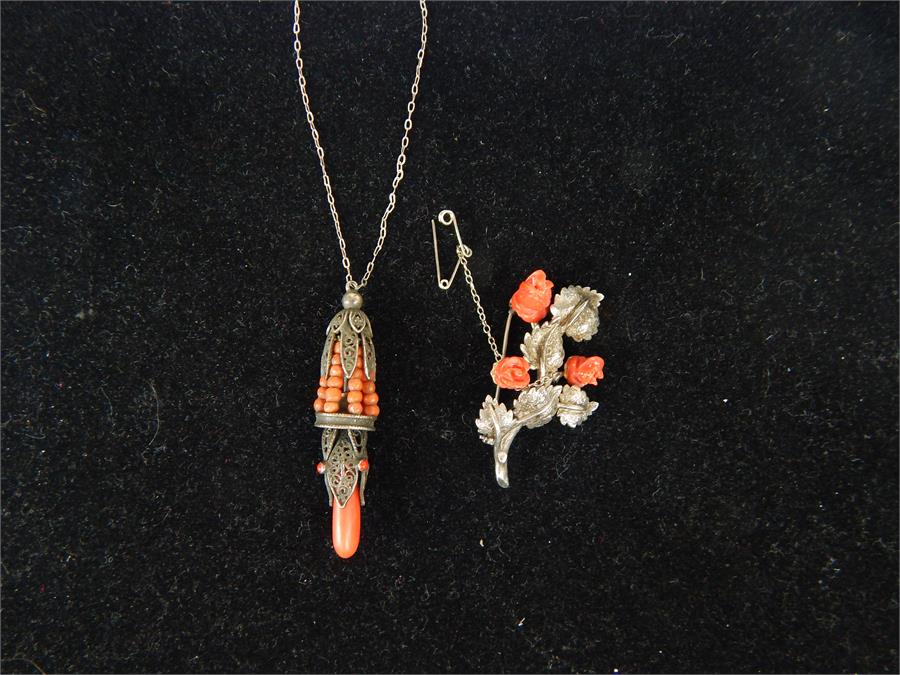 A silver and coral necklace together with a silver brooch