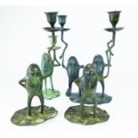 Four cast metal frog candlesticks.