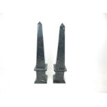 A pair of large black marble obelisks