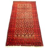 A Persian rug with a repeating design on a red field